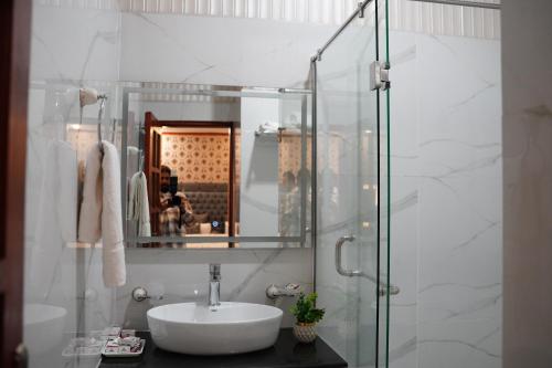 a bathroom with a sink and a glass shower at Hotel Grand Orchard in Lahore