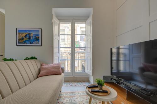 a living room with a couch and a large television at The Secret - R5 in Senglea