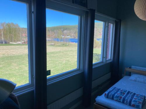 a bedroom with two windows with a view of a field at Tängerdalens camping och café in Övertänger