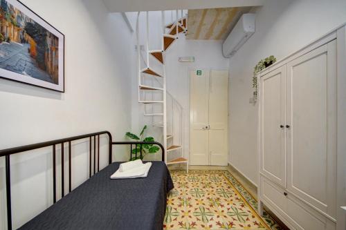 a small room with a bed and a staircase at The Secret - R5 in Senglea