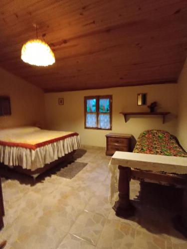 a bedroom with two beds and a wooden ceiling at Ecoturismo Tripuí in Aiuruoca