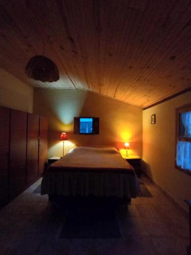 a bedroom with a bed and a tv on the wall at Ecoturismo Tripuí in Aiuruoca