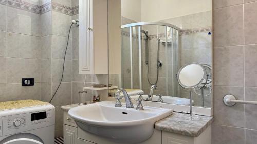 a bathroom with a sink and a washing machine at A Due Onde, Viola Mare in Alassio