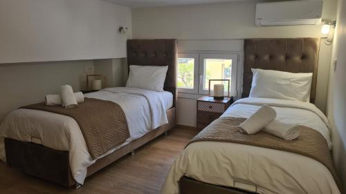 a bedroom with two beds and a window at JP Luxury Apartment 2 in Chios