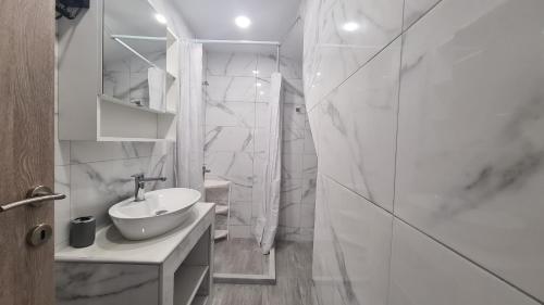a white bathroom with a sink and a shower at JP Luxury Apartment 2 in Chios