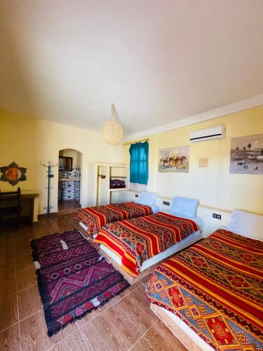 two beds in a room with colorful blankets at Merzouga Hotel Activities in Merzouga