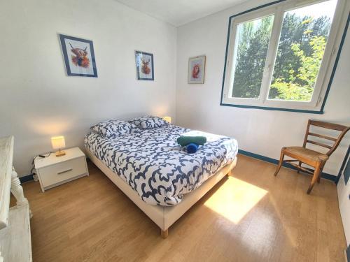a bedroom with a bed and a chair and a window at Vir'Volcans - Terrasse Parking Garage privatif in Romagnat