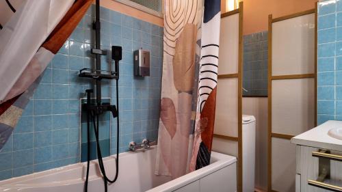 a bathroom with a shower with a baseball shower curtain at FLORAC AUTHENTIQUE in Florac