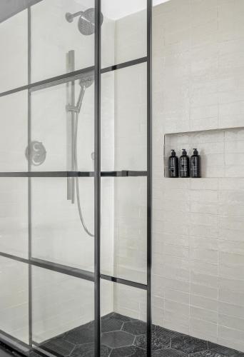 a shower with a glass door in a bathroom at The Greenleigh, River Oaks, Autograph Collection in Houston