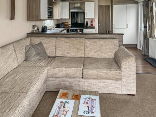 a living room with a couch and a kitchen at Pebbles in Pakefield