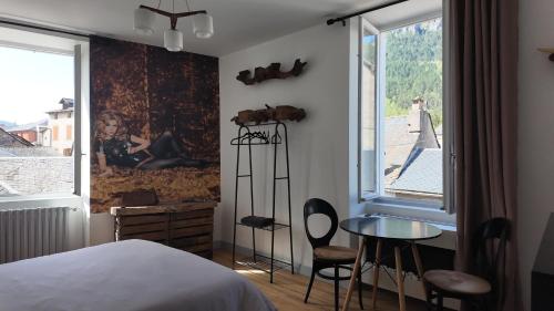a bedroom with a bed and a table and a window at FLORAC AUTHENTIQUE in Florac