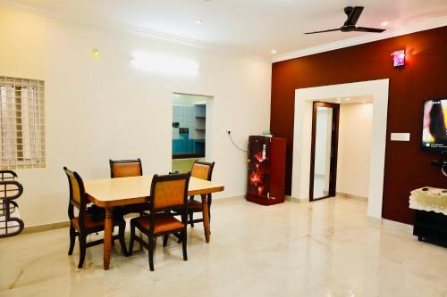 a dining room with a table and chairs at Mercury JKR Residency in Yelagiri