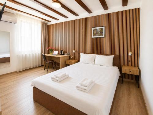 a bedroom with a large bed with two towels on it at Confort INN in Otopeni