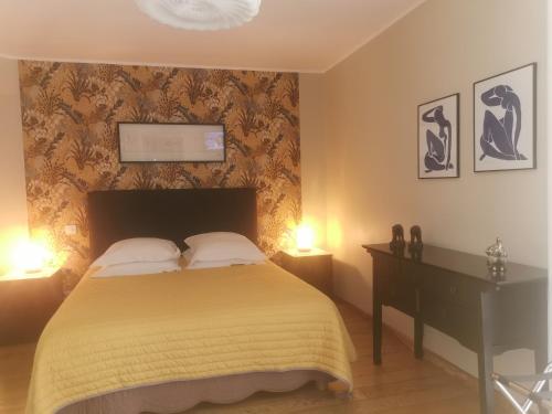 a bedroom with a bed and a desk and two lamps at U Muzzelo in Oletta