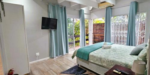a bedroom with a bed and a large window at Daniel's Sunset Garden in Richards Bay