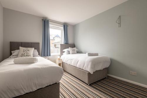 a bedroom with two beds and a window at Admiralty Lane - No 4 in Elie