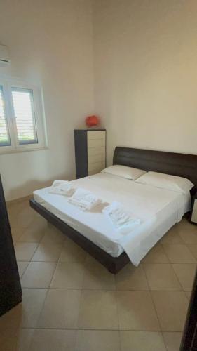 a bedroom with a large bed with white sheets at Dimora sul mare in Policoro