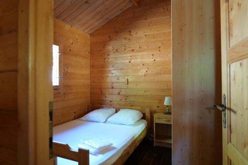 a small bedroom with a bed in a wooden room at Saut du moine in Simiane-la-Rotonde
