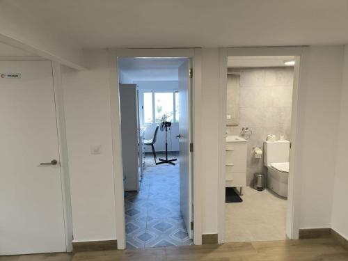 a white bathroom with a sink and a toilet at Casa del Sol in Gandía
