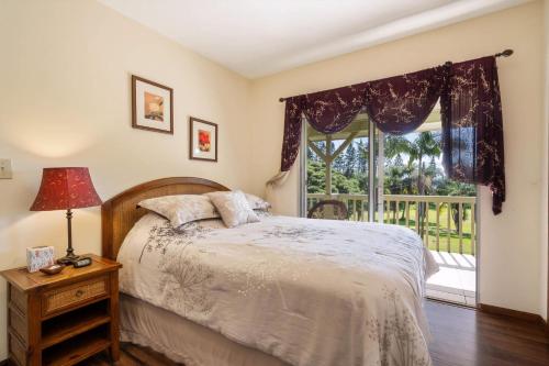 a bedroom with a bed and a window with a view at Hale Kamāoa Naalehu in Naalehu