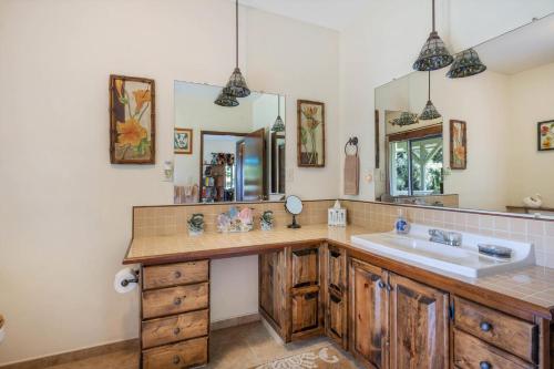 a bathroom with a sink and a mirror at Hale Kamāoa Naalehu in Naalehu