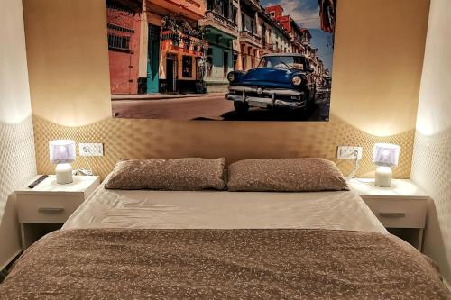 a bedroom with a bed and a picture of an old car at Casa del Sol in Gandía