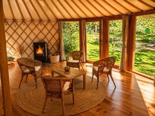 a room with a table and chairs and a fireplace at Jurty u jezírka in Mostek