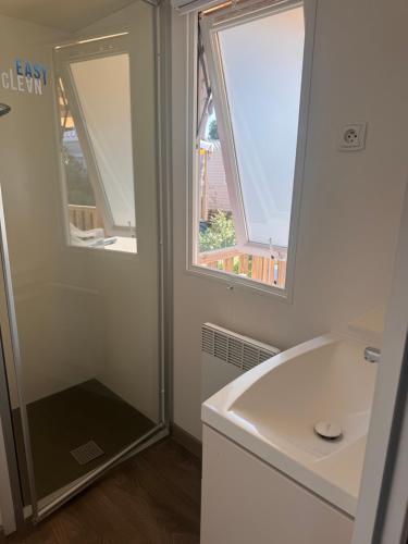a bathroom with a sink and two windows at Escale Sud in Canet-en-Roussillon