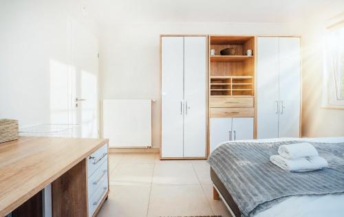 a bedroom with a bed and a desk and cabinets at Stunning 2 bed Mamer free parking in Mamer