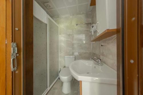 a white bathroom with a toilet and a sink at Elikti Otel in Ardeşen