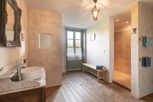 a large bathroom with a tub and a sink at Camping and Gîtes - Le Mas d'Ayen in Ayen