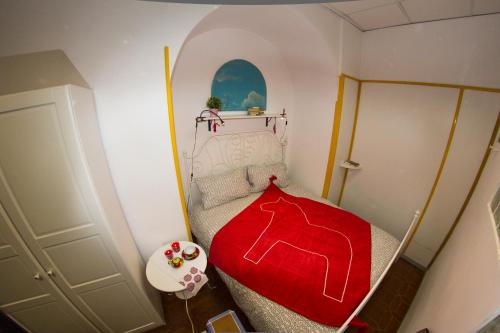 a small bedroom with a red blanket on a bed at A Casa Di Agata in Pellezzano