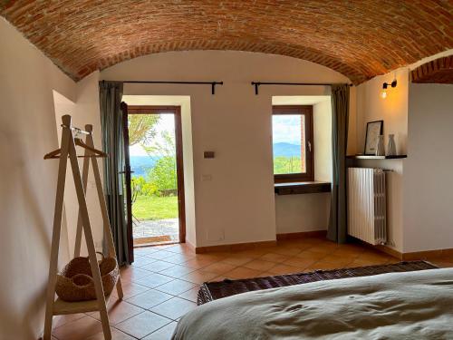 a bedroom with a bed and a large window at B&B Casa Oleandro in Chiaverano