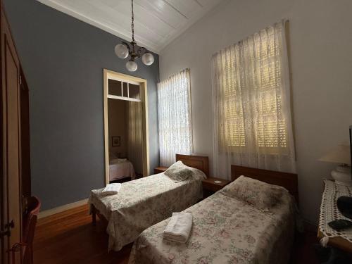 a bedroom with two beds and a window at Casarão Cidade Imperial in Petrópolis