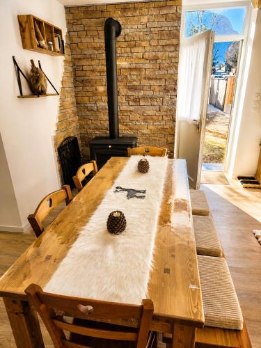 a wooden table in a room with a fireplace at Le Terrier- Chaleureux avec Jardin privatif et parking pour 2 voitures in Briançon