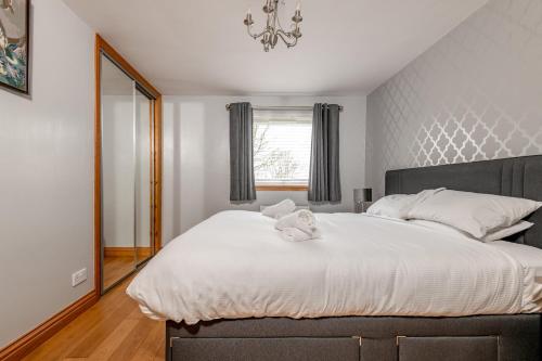 a bedroom with a large bed with white sheets at Dreelside - No 50 in Anstruther