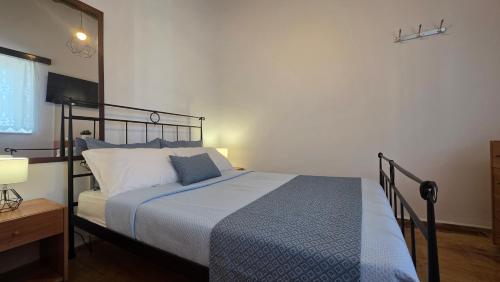 a bedroom with a bed with a blue and white blanket at Spitaki Milos in Tripiti