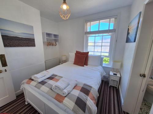a bedroom with a bed with two towels on it at The Studio Apartment in Weymouth