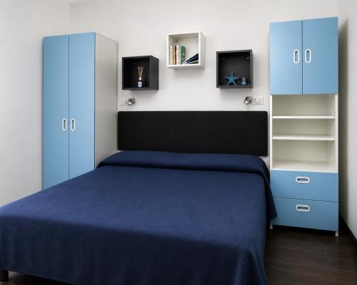 a bedroom with a blue bed and cabinets at Villino Isò in La Spezia