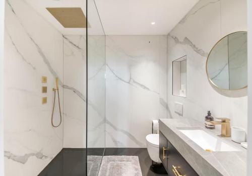 a bathroom with a toilet and a sink and a mirror at 3 Bedroom, 3 bathroom large flat with sea views! in Hastings