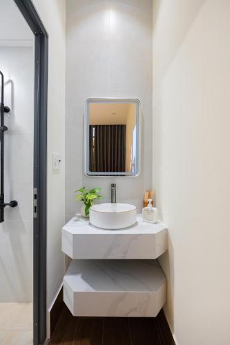 a bathroom with a sink and a mirror at Cái Vườn Ấm in Lái Thiêu