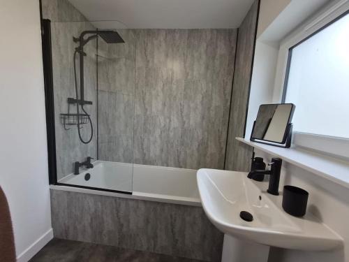 a bathroom with a sink and a bath tub at Spacious 3 Bedroom House with Large Drive in Dundee