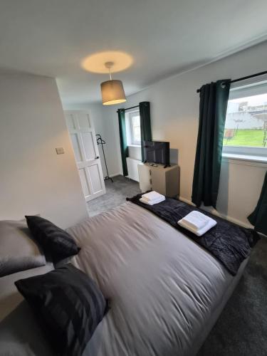 a large bed in a room with a window at Spacious 3 Bedroom House with Large Drive in Dundee
