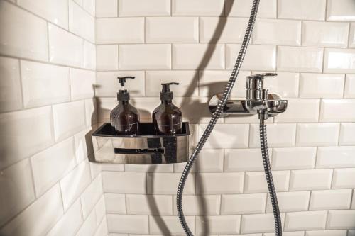 a bathroom with a shower with two glass bottles at Prance namai in Plateliai