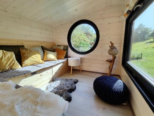 a small room with a bed and a window at La mini maison du Lama in Libin