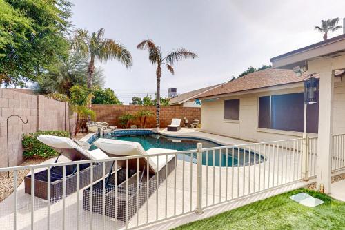 a backyard with a swimming pool and a fence at Suitewater in Peoria