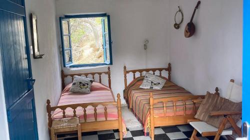 two beds in a small room with a window at The Priest House in Makrotándalon