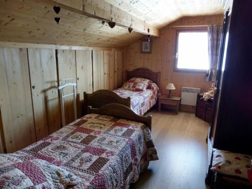 a bedroom with two beds in a log cabin at Chambres d'hôtes les Terrasses de Varme in Sallanches