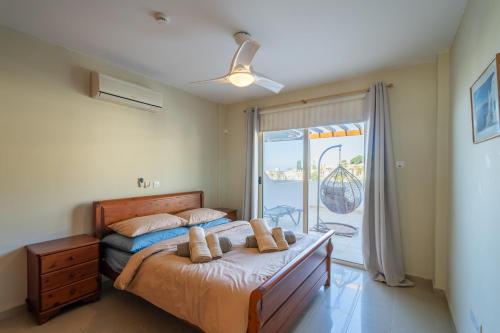 a bedroom with a bed and a window with a view at Peyia Hilltop Retreat - Village Views & Sunsets in Peyia