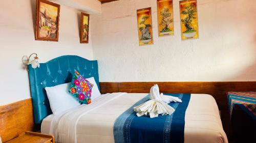 a bedroom with a bed with a blue head board at Hostal sambleño cusco Piero suite in Cusco